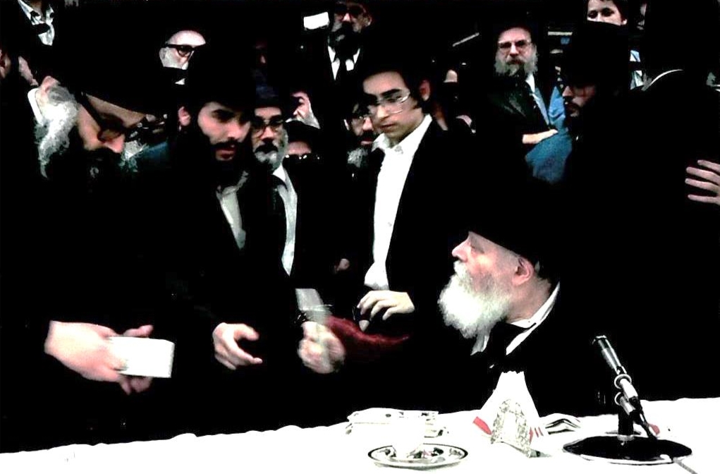 ר' שלום פוזילוב מקבל מכ"ק אדמו"ר מלך המשיח שליט"א חבילת דולרים בתור 'טנקיסט' בא' ההתוועדויות